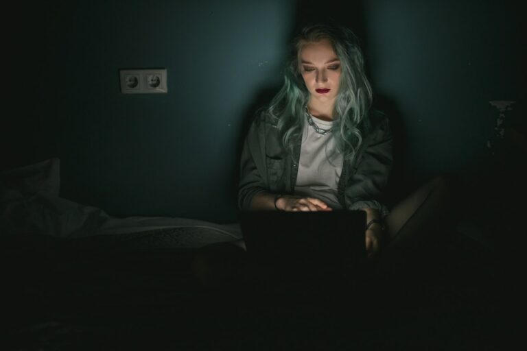 Girl working on a laptop in a dark room